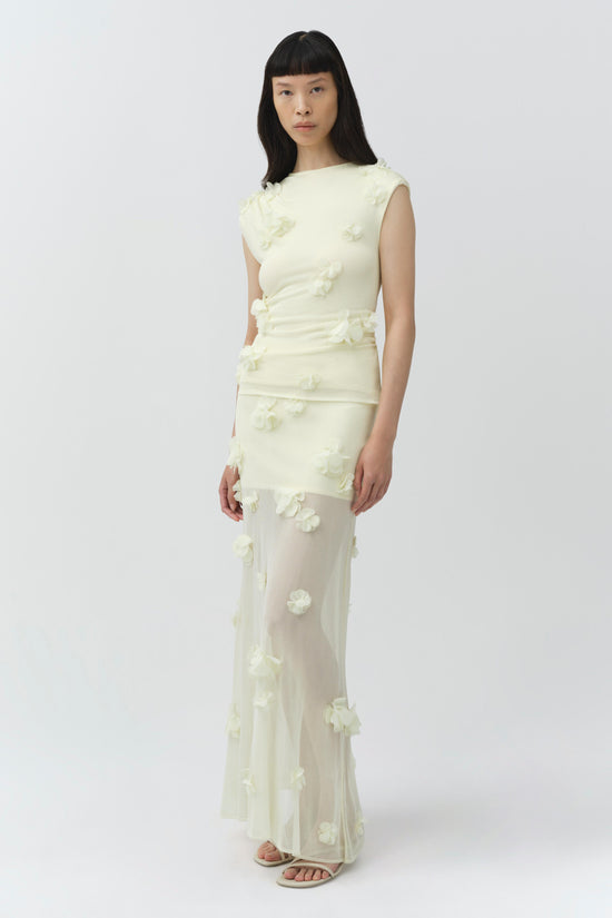 Cream midi skirt with white floral appliqué details, sheer mesh construction, worn with matching sleeveless top.