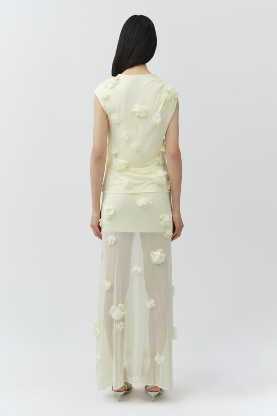 Cream sleeveless top with white floral appliqués, shown on model from behind.