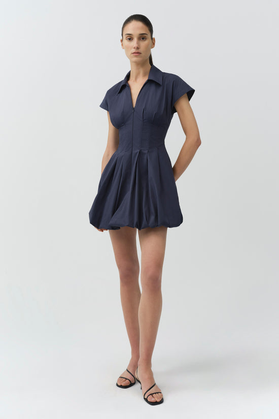 Navy cotton bubble mini dress with short sleeves, button front, and pleated skirt detail.