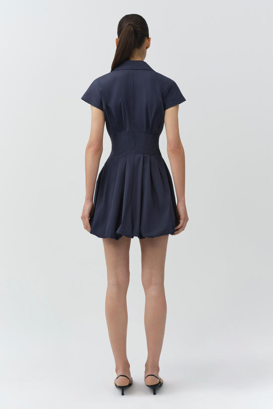 Navy blue cotton bubble mini dress with short sleeves, collar, and gathered skirt, shown from back view.