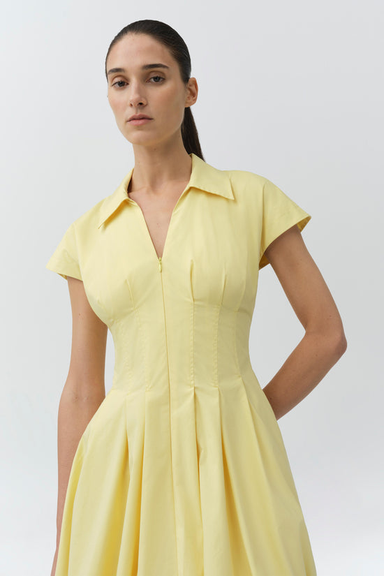 Yellow cotton mini dress with short sleeves, collared neckline, front zip closure, and pleated skirt.