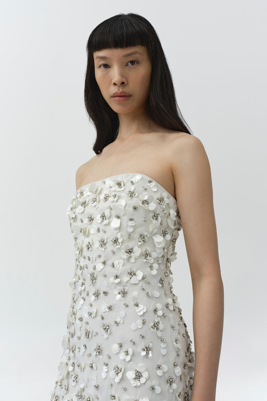 White strapless gown with sequin and petal embellishments covering the bodice and skirt.