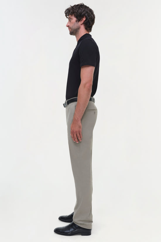 Man wearing beige cotton twill trousers with black shirt and belt, shown in side profile.