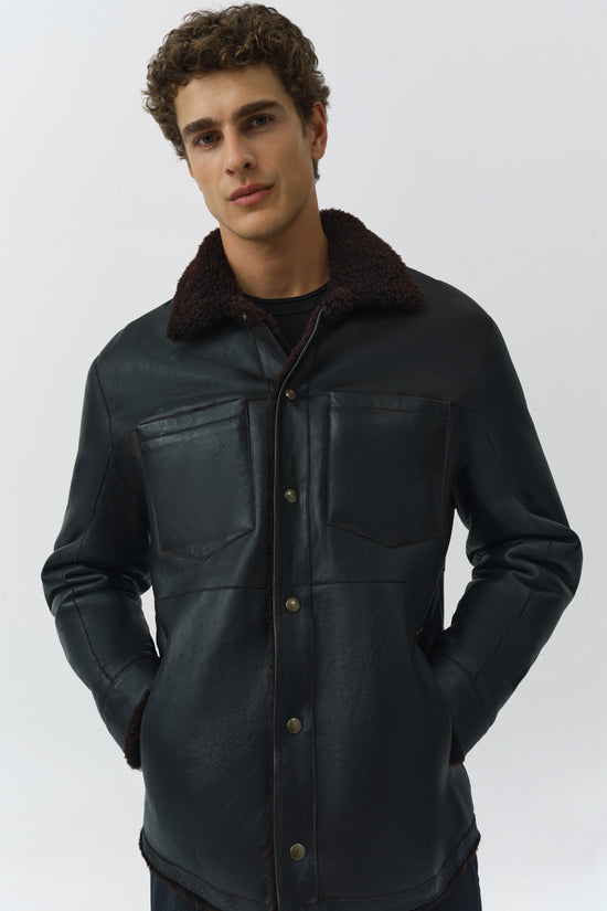 Black leather shirt jacket with dark fleece collar, chest pockets, and button front worn by male model.