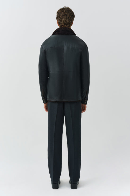 Man wearing dark navy shirt jacket with black fleece collar and matching navy pants, shown from back view.