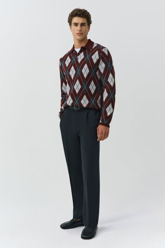 Burgundy argyle polo with white and navy diamond pattern, worn with navy trousers.