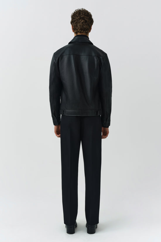 Man wearing black leather jacket with collar and waist belt, shown from back view.