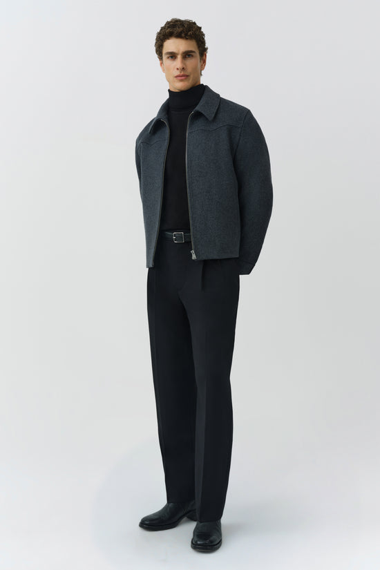 Man wearing charcoal gray wool jacket with collar over black turtleneck and black trousers.