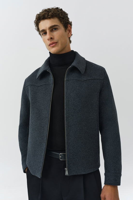 Charcoal wool jacket with front zip closure, collar, and long sleeves worn over black turtleneck.