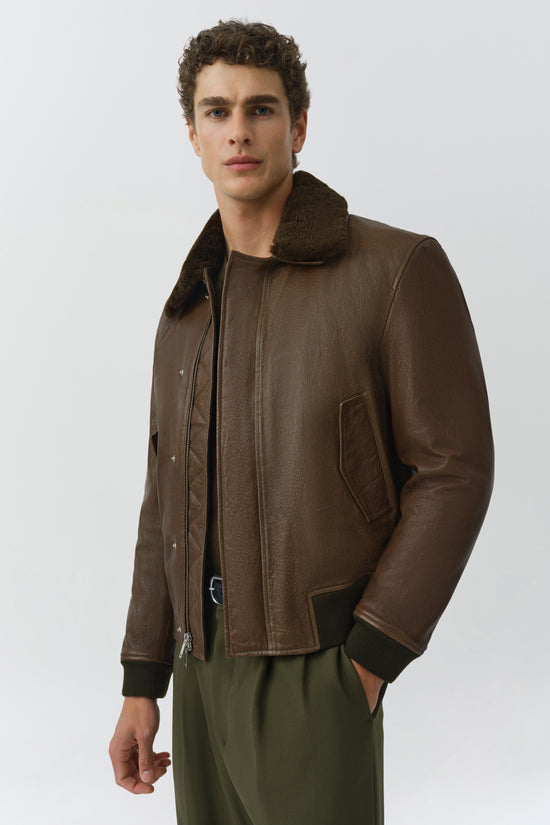 Brown leather jacket with shearling collar, zip front, and ribbed cuffs on male model.