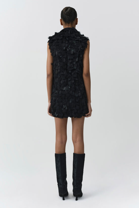 Black sleeveless mini dress with layered feather detailing throughout, shown on model from back view.