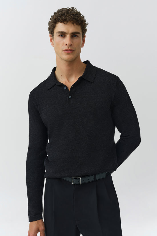 Man wearing black knit polo shirt with collar and button placket.