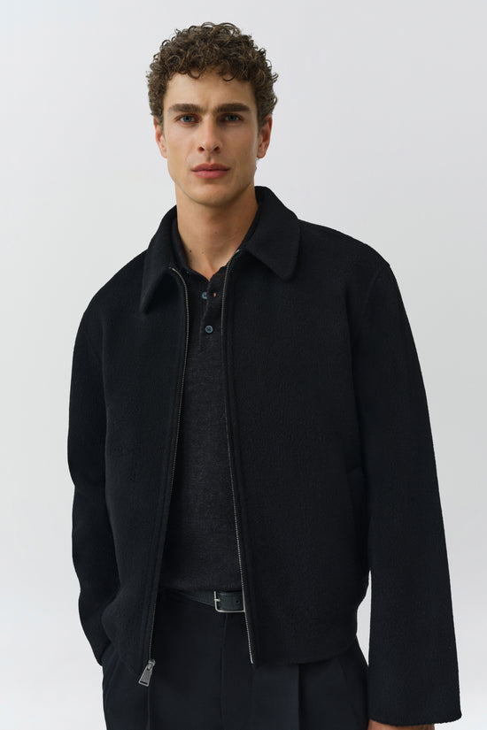 Black wool Quinn jacket with collar, zipper front, and button closure on layered shirt.