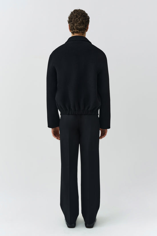 Man wearing black Quinn Jacket with coordinating pants, shown from back view against neutral background.