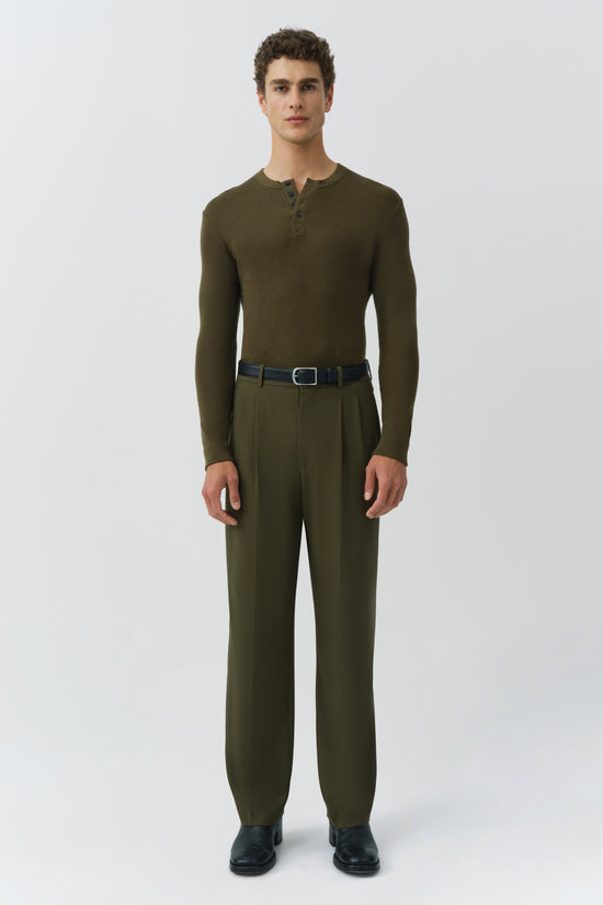 Man wearing olive green ribbed henley shirt with matching trousers, black belt, and dark shoes.