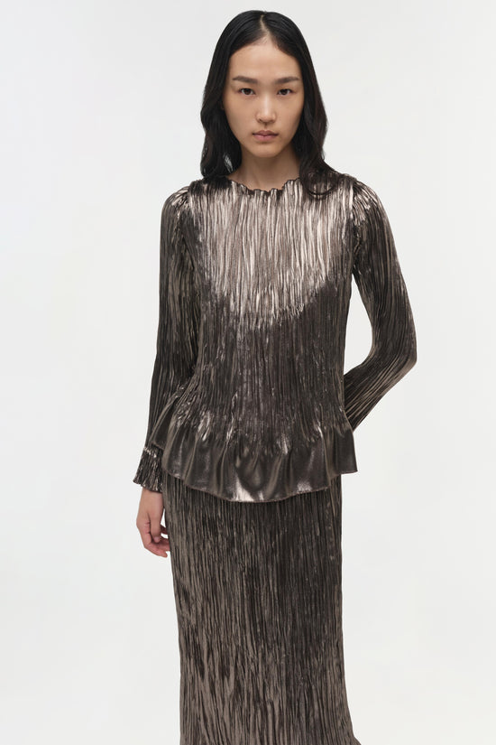 Metallic gunmetal plissé top with long sleeves and crew neckline worn with matching plissé skirt.