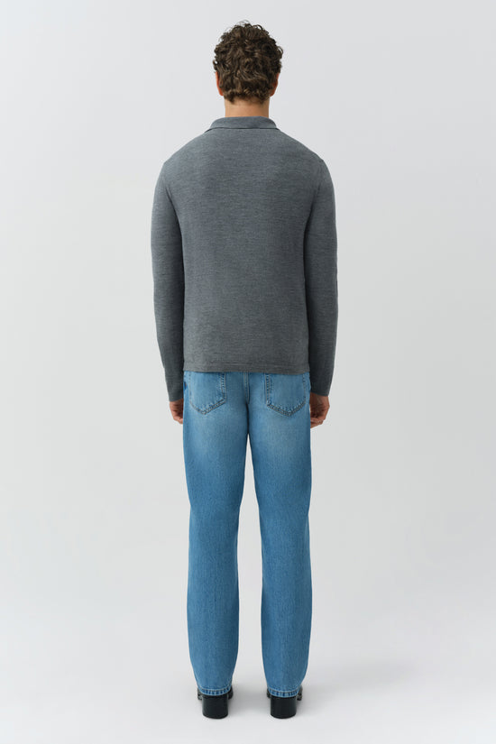 Man wearing gray knit polo with collared neckline and long sleeves, styled with blue jeans, shown from back.