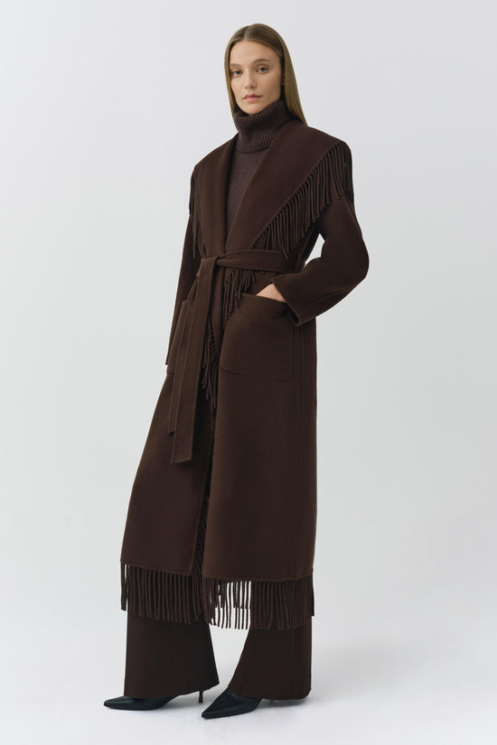 Brown wool coat with fringe trim on shoulders and hem, belted waist, and front pockets.