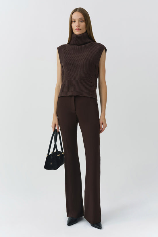 Brown ribbed sleeveless turtleneck top with cropped fit on model wearing matching brown pants.