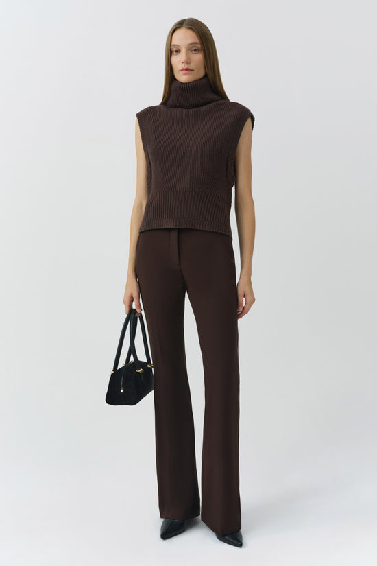 Brown ribbed sleeveless turtleneck top with cropped fit on model wearing matching brown pants.