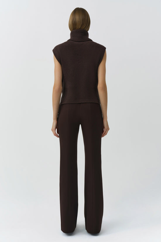 Woman wearing a dark brown ribbed sleeveless turtleneck top with matching wide-leg pants, shown from behind.