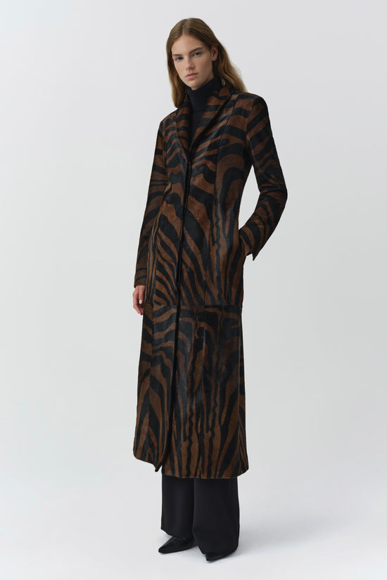 Brown and black zebra-striped calf hair coat with notch lapels and front pockets on model.