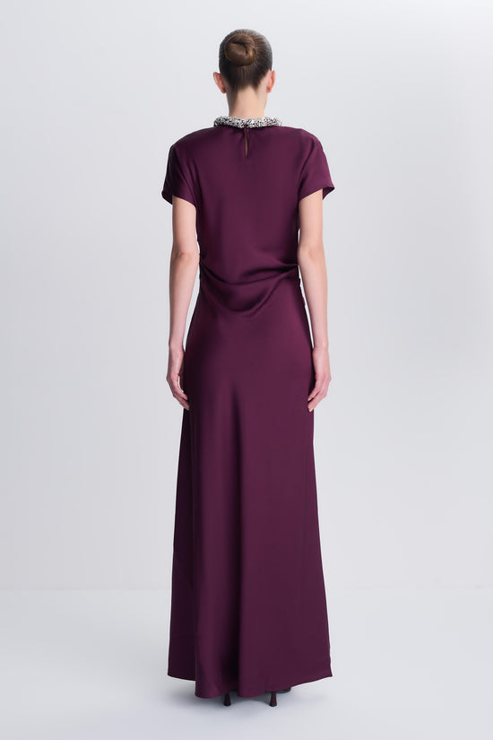 Burgundy satin floor-length gown with short sleeves and beaded neckline, shown from back view.