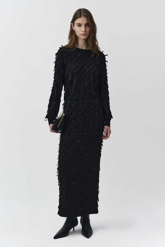 Black knit dress with beaded fringe embellishment throughout, long sleeves, and midi length.