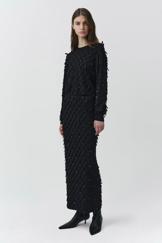 Black knit top with fringe and beaded embellishments throughout, long sleeves, crew neckline.
