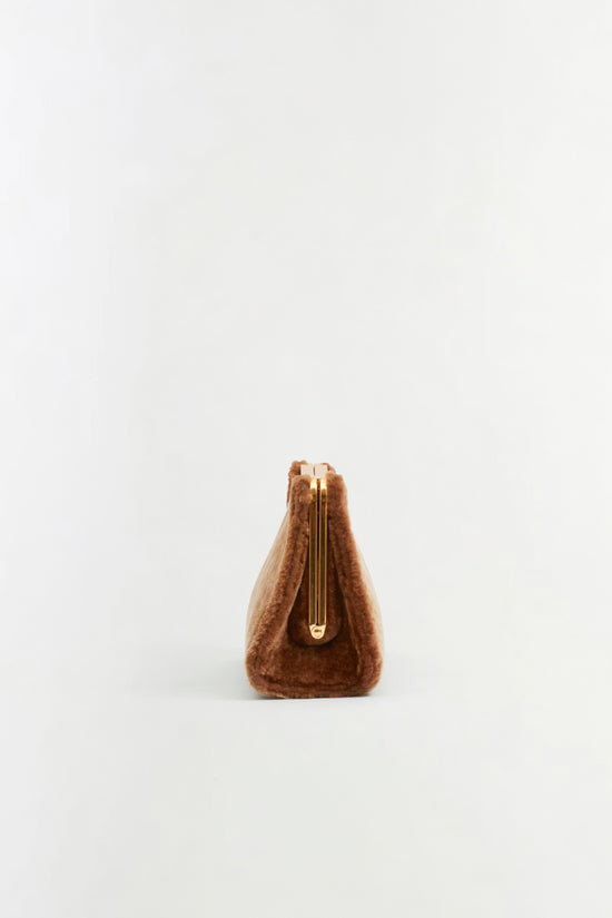 Brown shearling clutch with gold-tone top frame and center zip closure.