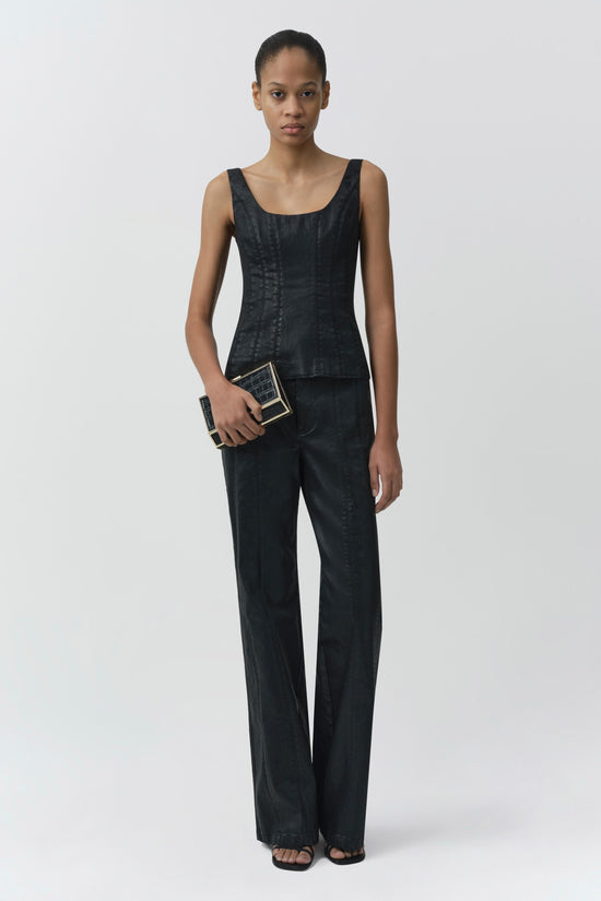 Black coated denim bustier top with scoop neckline and sleeveless design, worn with matching denim pants.