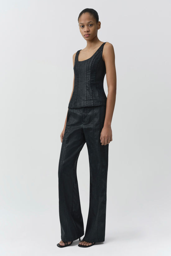 Black coated denim trousers with wide legs and flat front, styled with matching sleeveless top.