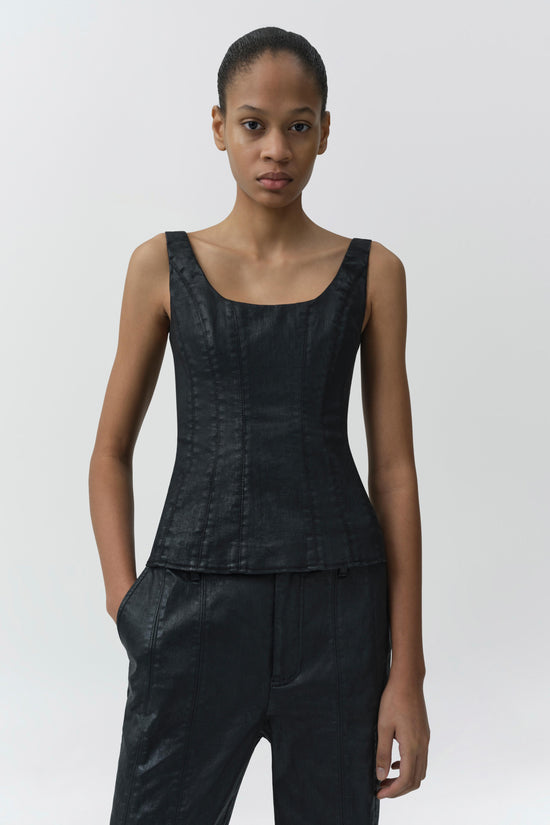 Black coated denim bustier top with scoop neckline and fitted bodice worn with matching pants.