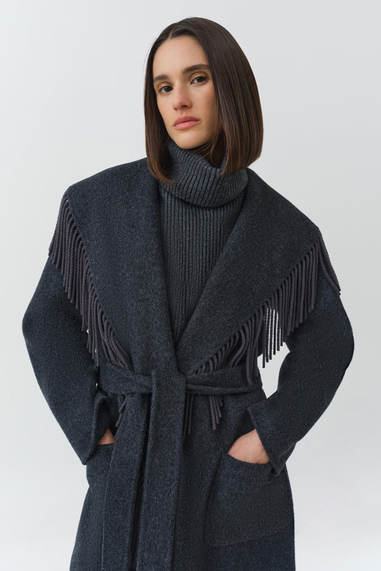 Charcoal wool coat with fringe trim on shoulders and sleeves, belt at waist, and front pockets.