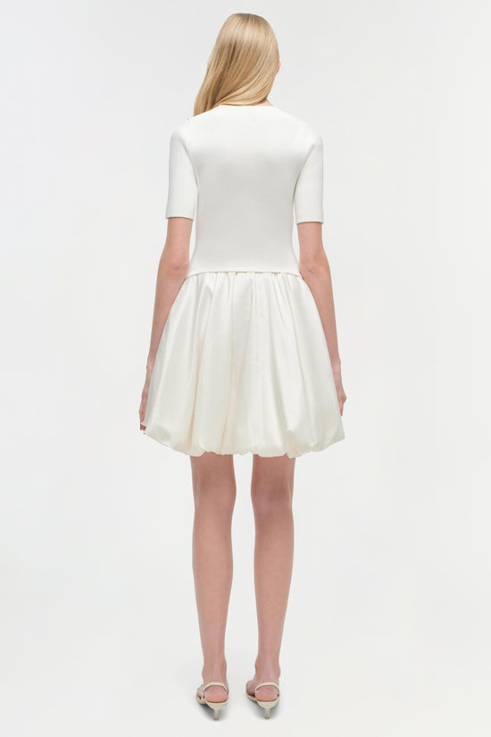 White mini dress with ribbed short-sleeve top and gathered skirt, shown from back view.
