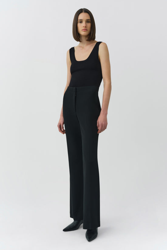 Black sleeveless tank top with a scoop neckline, shown on a model wearing matching black wide-leg pants.