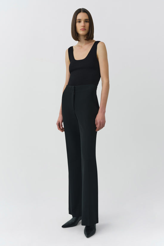 Black sleeveless tank top with a scoop neckline, shown on a model wearing matching black wide-leg pants.