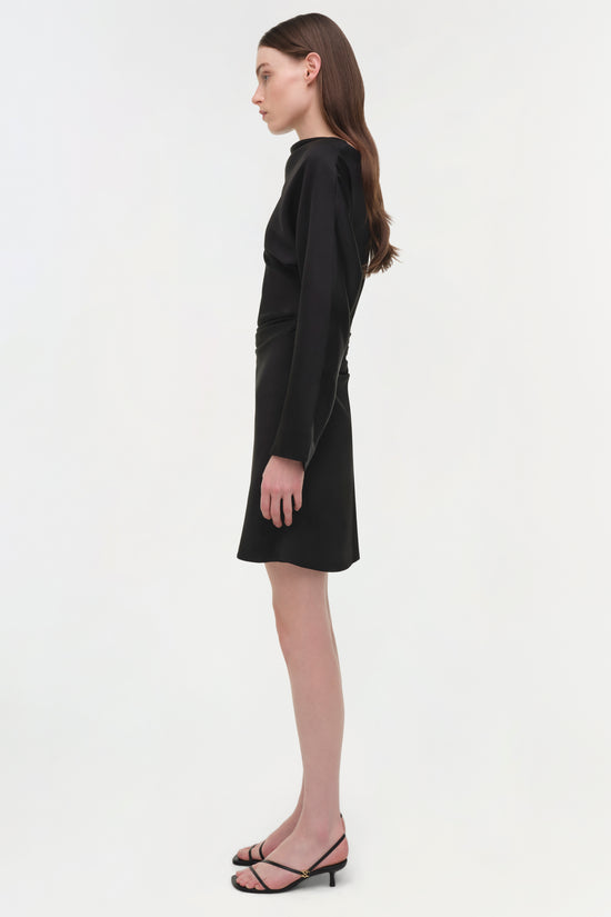 Black satin mini dress with long sleeves shown on model in profile view.