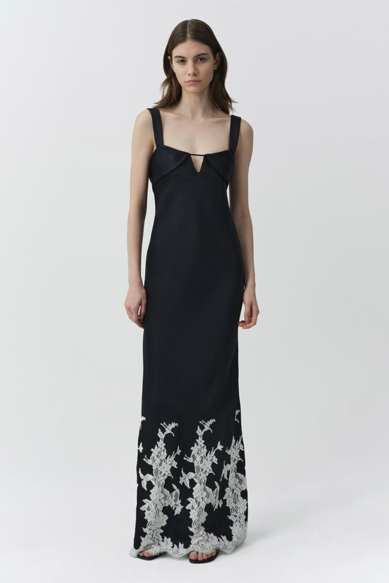 Black sleeveless floor-length gown with sweetheart neckline and white lace floral pattern at hem.