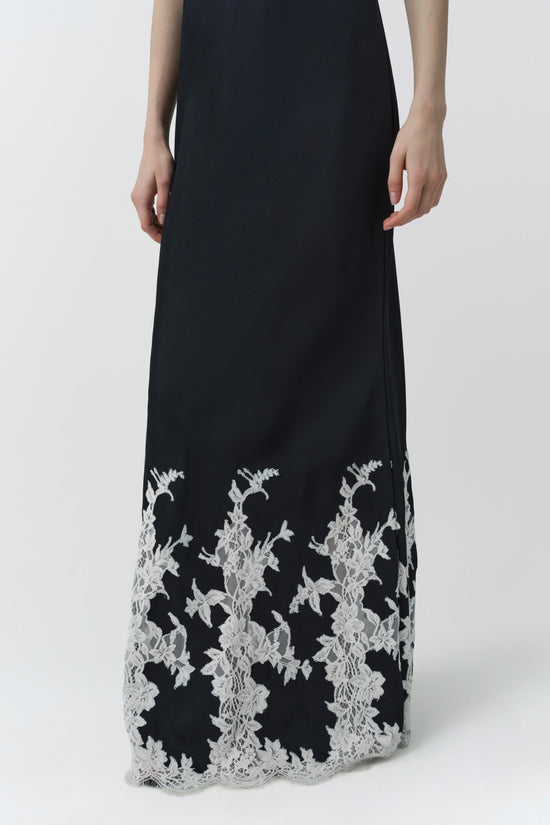 Black sleeveless gown with white lace floral embroidery along the hem and lower skirt.