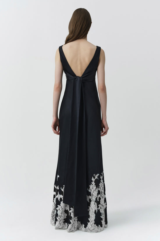 Black sleeveless gown with open back tie and white lace trim at hem.