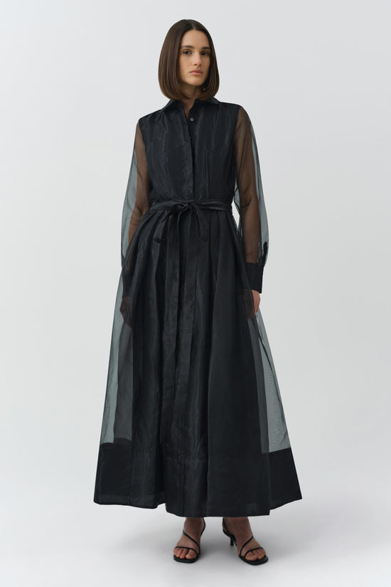 Black Montgomery dress with sheer mesh sleeves, button front, tie waist, and full skirt on model.