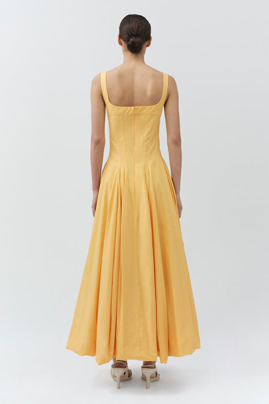 Woman wearing a yellow cotton midi dress with square neckline, sleeveless design, and fitted bodice with pleated skirt, shown