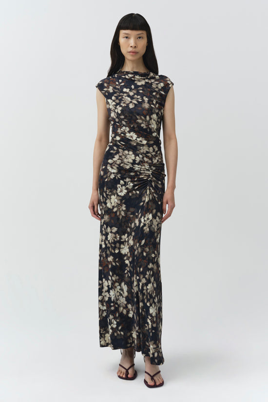 Black midi dress with cream floral print and ruched side detailing, short sleeves, worn with black sandals.