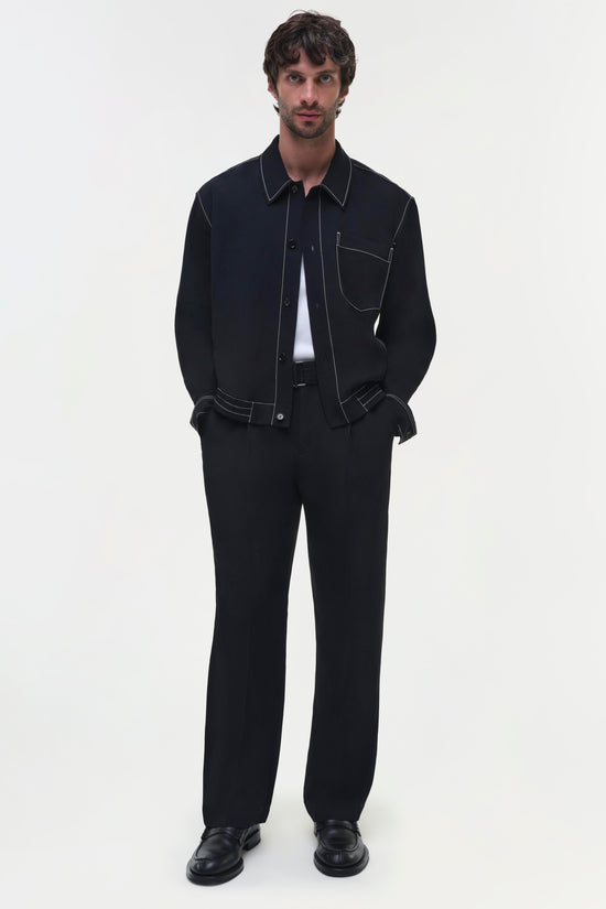 Black straight-leg trousers worn with matching black shirt and white undershirt.