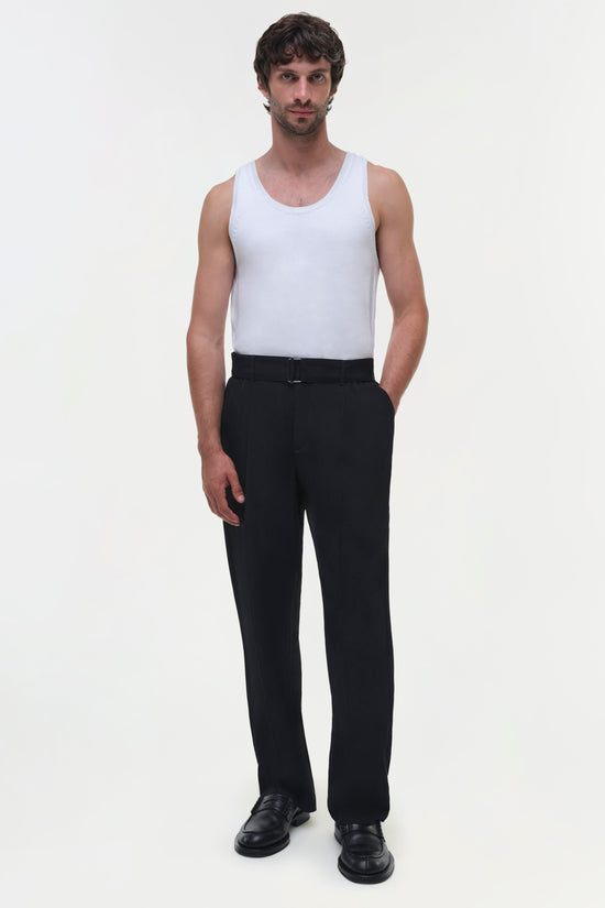 Black flat-front trousers with high waist and straight leg, worn with white tank top.