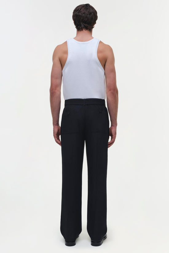 Black wide-leg trousers with high waist and pleated front, shown from back view on model wearing white tank top.