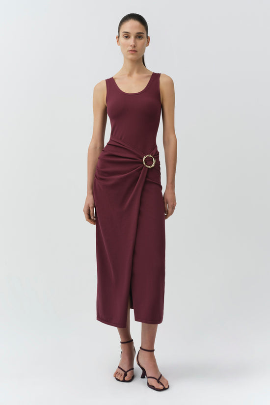 Burgundy sleeveless knit midi dress with draped side detail and circular buckle accent at waist.
