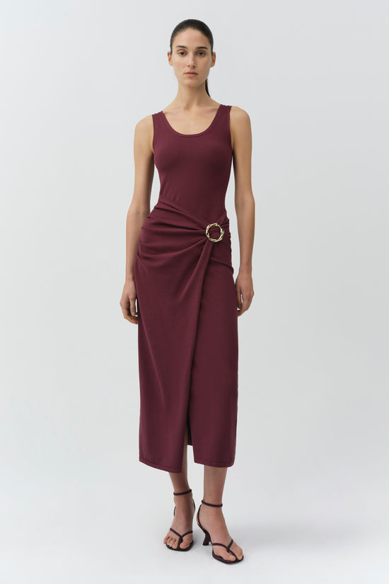 Burgundy sleeveless knit midi dress with draped side detail and circular buckle accent at waist.