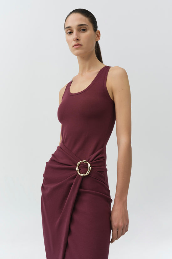 Burgundy sleeveless knit midi dress with draped side ruching and gold circular buckle detail at waist.
